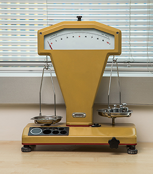 Yellow lab balance with calibration weights on one plate
