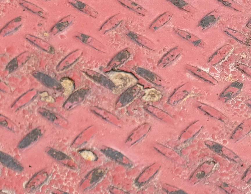 Steel deck painted red with some paint wearing off so the steel shows through