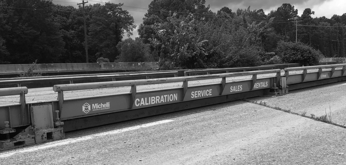 A Michelli rental truck scale with magnets featuring the Michelli Weighing & Mesaurement logo and the words Calibration, Service, Sales & Rentals on the side.